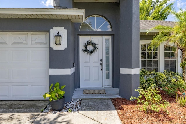 138 Hidden Pointe Ln, Groveland, FL 34736 - view of exterior entry with a garage and stucco siding