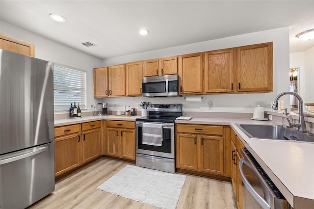 138 Hidden Pointe Ln, Groveland, FL 34736 - kitchen featuring stainless steel appliances, light wood-type flooring, light countertops, brown cabinets, and recessed lighting