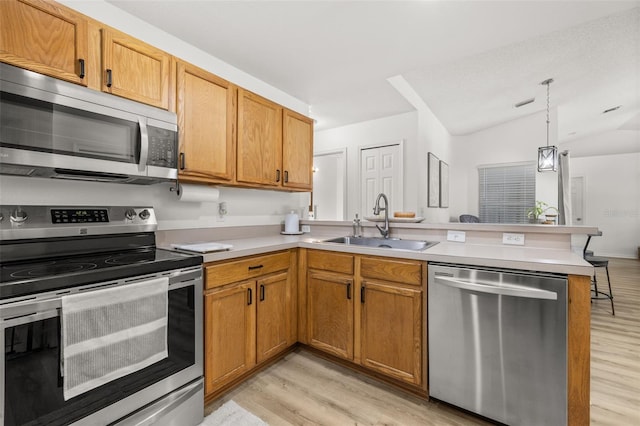 138 Hidden Pointe Ln, Groveland, FL 34736 - kitchen featuring appliances with stainless steel finishes, a peninsula, light wood finished floors, light countertops, and lofted ceiling