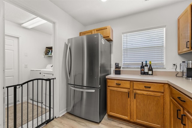 138 Hidden Pointe Ln, Groveland, FL 34736 - kitchen featuring freestanding refrigerator, washing machine and clothes dryer, light wood-style floors, and light countertops