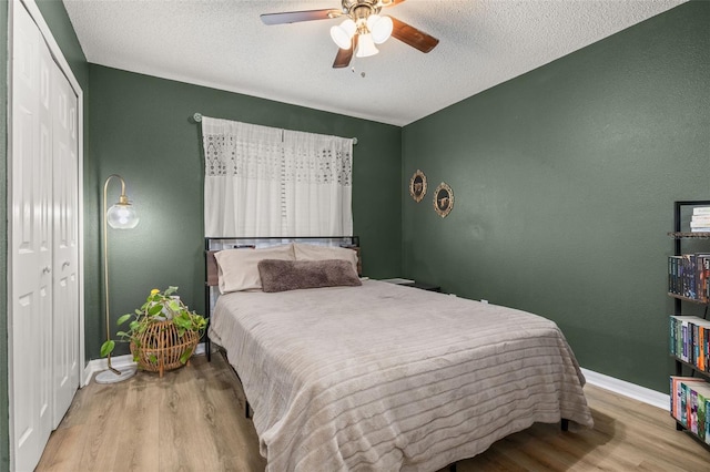 138 Hidden Pointe Ln, Groveland, FL 34736 - bedroom with wood finished floors, a textured ceiling, a closet, and ceiling fan