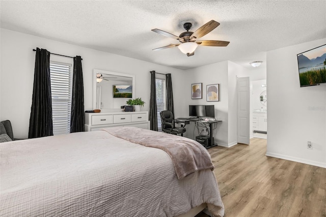 138 Hidden Pointe Ln, Groveland, FL 34736 - bedroom featuring light wood-type flooring, a textured ceiling, ceiling fan, and ensuite bath