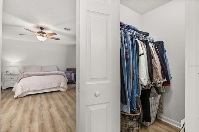 138 Hidden Pointe Ln, Groveland, FL 34736 - bedroom with a textured ceiling, light wood finished floors, and a ceiling fan