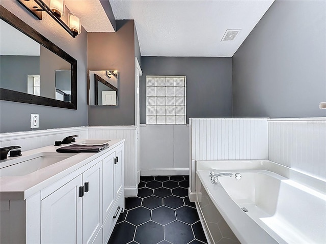 238 Sunridge Woods Blvd, Davenport, FL 33837 - full bathroom featuring double vanity, wainscoting, a garden tub, and tile patterned flooring