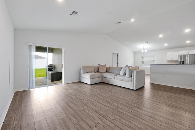 4505 Hummingbird Ln, Haines City, FL 33844 - living room with lofted ceiling, wood finished floors, and recessed lighting