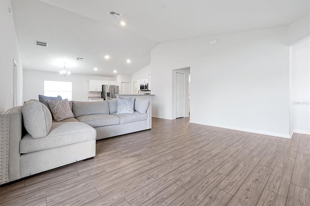 4505 Hummingbird Ln, Haines City, FL 33844 - living area featuring vaulted ceiling, light wood finished floors, and a chandelier