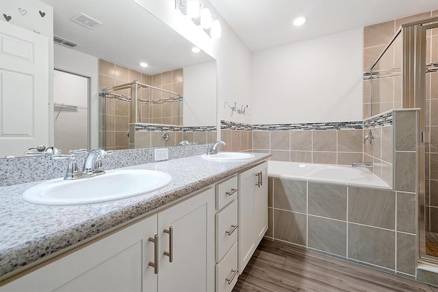 4505 Hummingbird Ln, Haines City, FL 33844 - full bathroom with a shower stall, double vanity, a bath, and wood finished floors