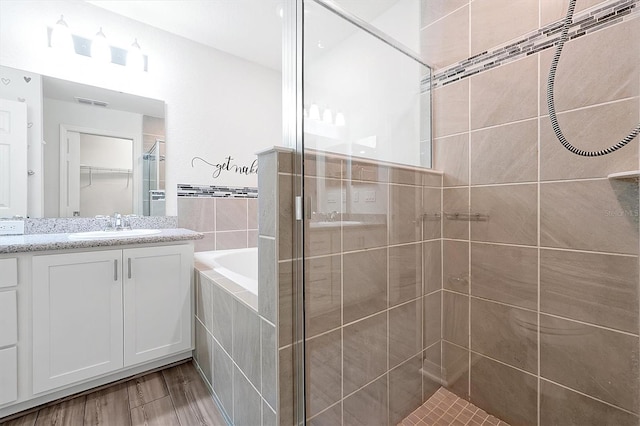 4505 Hummingbird Ln, Haines City, FL 33844 - bathroom featuring a stall shower, a garden tub, vanity, and wood finished floors