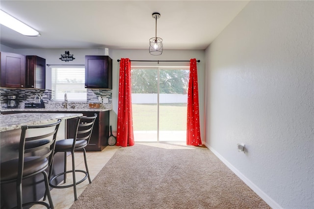 10 Pine Track Trl, Ocala, FL 34472 - kitchen featuring tasteful backsplash, light stone counters, decorative light fixtures, a textured wall, and a kitchen bar