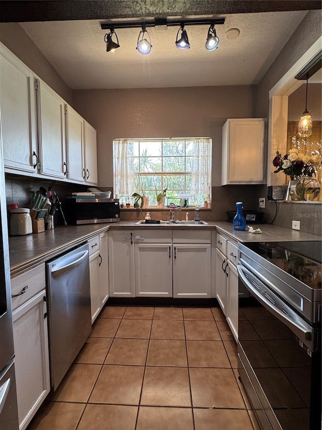 760 Bearcreek Dr, Bartow, FL 33830 - kitchen with appliances with stainless steel finishes, white cabinetry, rail lighting, and light tile patterned floors