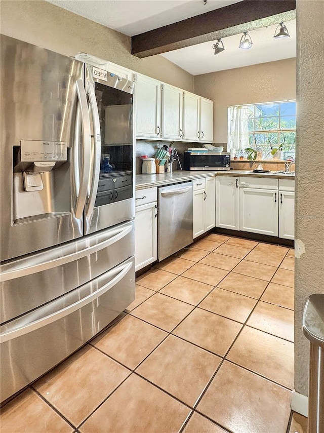 760 Bearcreek Dr, Bartow, FL 33830 - kitchen featuring appliances with stainless steel finishes, white cabinets, light tile patterned flooring, a textured wall, and beam ceiling