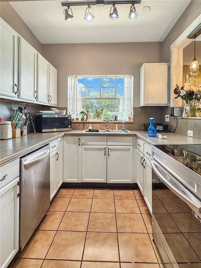 760 Bearcreek Dr, Bartow, FL 33830 - kitchen featuring appliances with stainless steel finishes, white cabinetry, light tile patterned floors, and rail lighting
