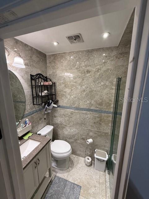 2013 Marilyn Ave, Winter Haven, FL 33881 - bathroom featuring tile walls, vanity, and bathing tub / shower combination