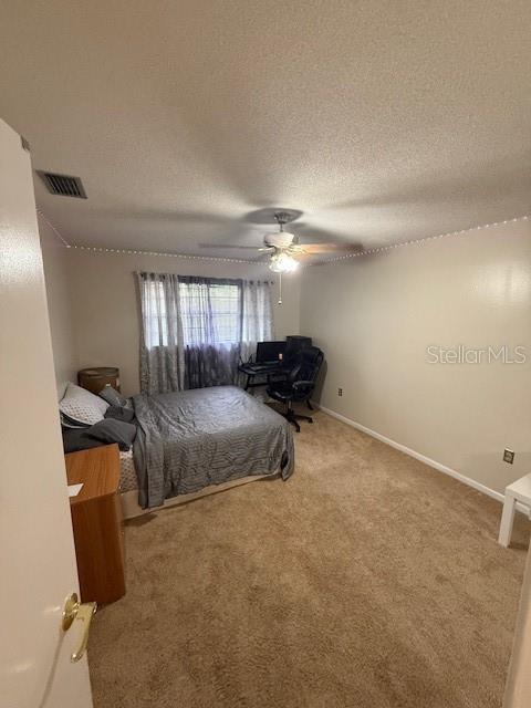 2013 Marilyn Ave, Winter Haven, FL 33881 - bedroom featuring carpet, a ceiling fan, and a textured ceiling