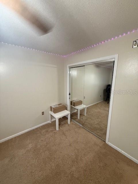 2013 Marilyn Ave, Winter Haven, FL 33881 - unfurnished bedroom with carpet, a closet, and a textured ceiling