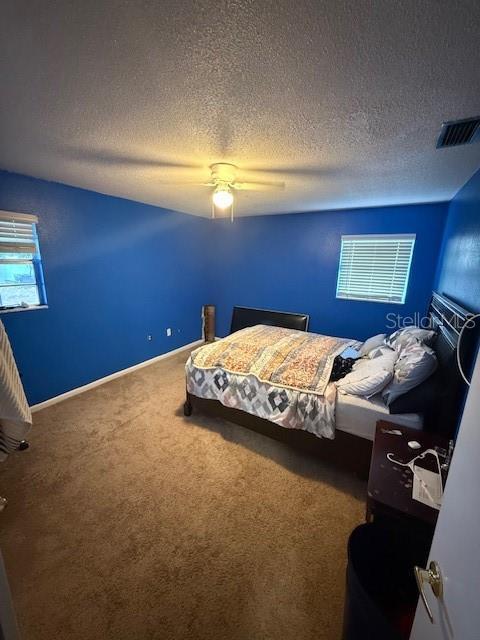 2013 Marilyn Ave, Winter Haven, FL 33881 - carpeted bedroom featuring a textured ceiling and a ceiling fan