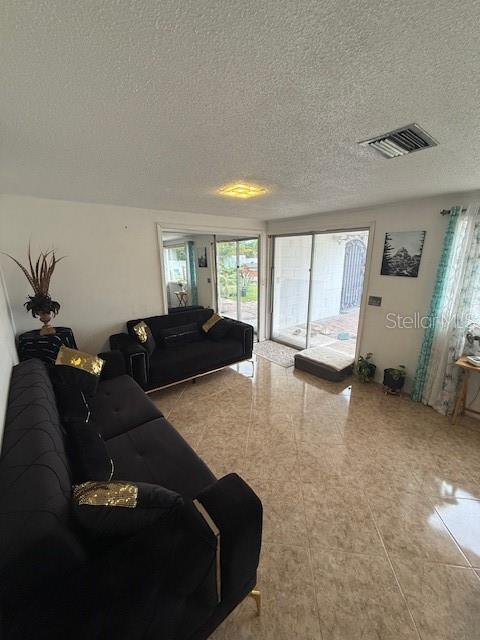 2013 Marilyn Ave, Winter Haven, FL 33881 - living area featuring a textured ceiling and tile patterned flooring