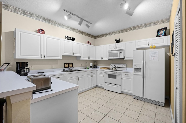 3111 Sun Lake Ct Unit B, Kissimmee, FL 34747 - kitchen featuring white appliances, rail lighting, a peninsula, light tile patterned flooring, and light countertops