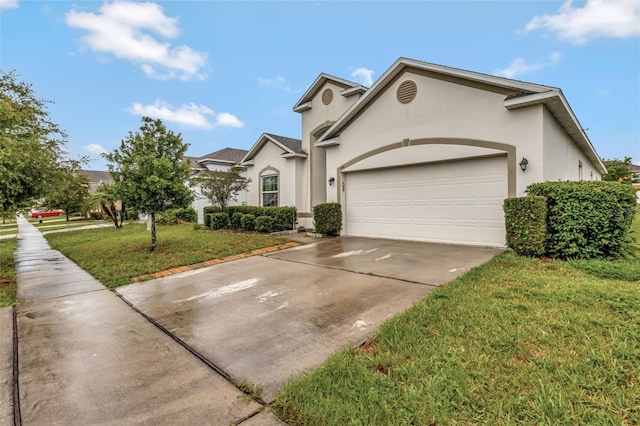 954 Revere Ave, Haines City, FL 33844 - view of front of house with stucco siding, driveway, a garage, and a front yard