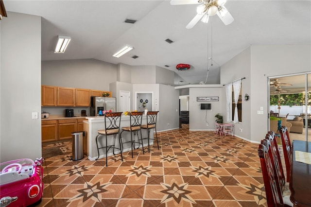 4428 Winding River Dr, Valrico, FL 33596 - kitchen with stainless steel refrigerator with ice dispenser, ceiling fan, a kitchen breakfast bar, light countertops, and high vaulted ceiling
