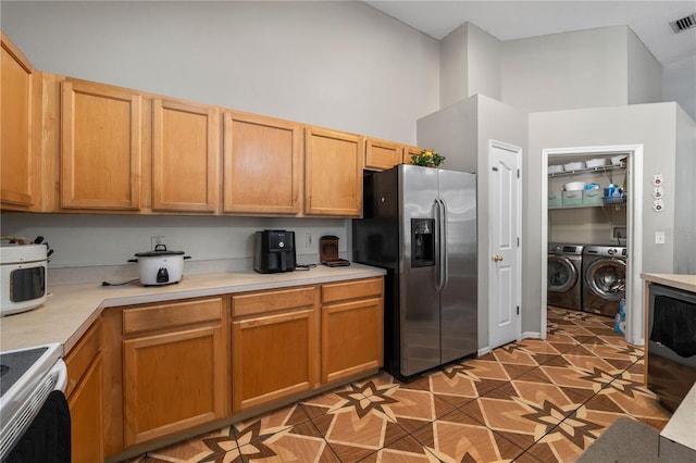 4428 Winding River Dr, Valrico, FL 33596 - kitchen featuring stainless steel fridge with ice dispenser, washer and dryer, stove, a high ceiling, and light countertops