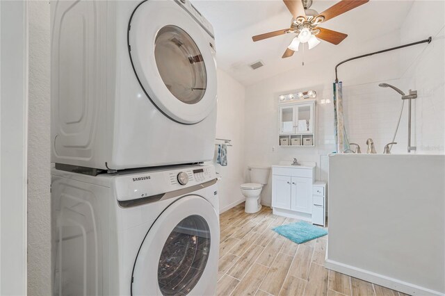 2343 St George Dr, Davenport, FL 33837 - laundry room with stacked washer / drying machine, light wood-style floors, and a ceiling fan