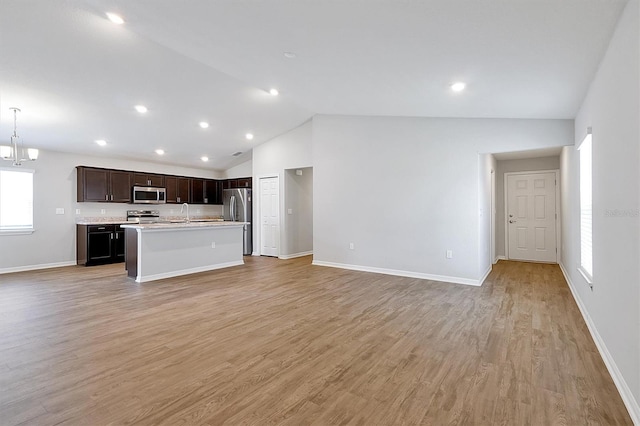 328 Lily Ln, Davenport, FL 33837 - unfurnished living room with lofted ceiling, light wood finished floors, and recessed lighting