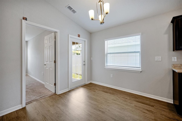 328 Lily Ln, Davenport, FL 33837 - unfurnished dining area with wood finished floors, a chandelier, and lofted ceiling