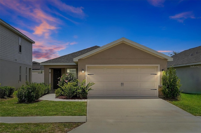 328 Lily Ln, Davenport, FL 33837 - ranch-style house with an attached garage, driveway, stucco siding, roof with shingles, and a yard