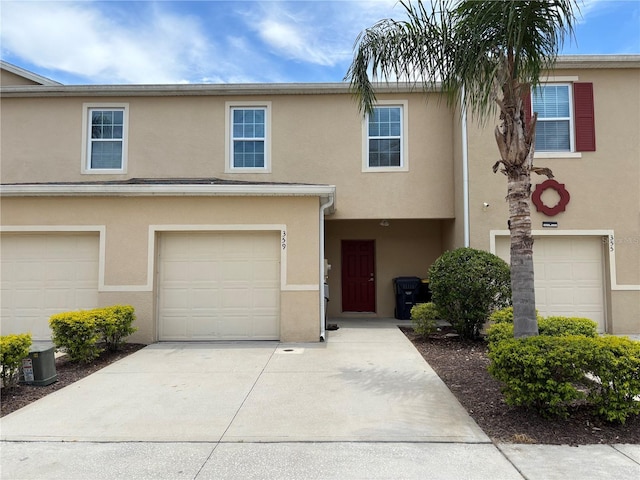 359 Arbor Lakes Dr, Davenport, FL 33896 - townhome / multi-family property with an attached garage, stucco siding, and concrete driveway