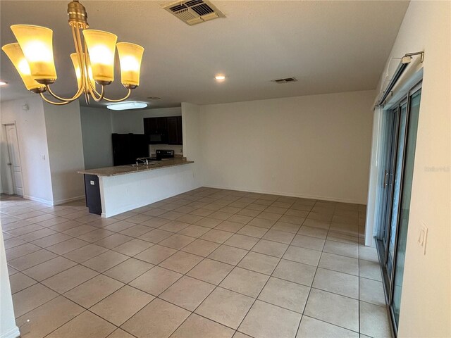 359 Arbor Lakes Dr, Davenport, FL 33896 - kitchen with light tile patterned floors, black microwave, a chandelier, open floor plan, and recessed lighting
