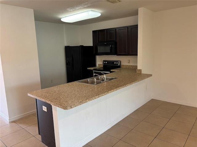 359 Arbor Lakes Dr, Davenport, FL 33896 - kitchen with black appliances, light tile patterned floors, light countertops, a peninsula, and a textured ceiling