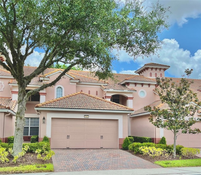 8401 Riverdale Ln Unit 8401, Davenport, FL 33896 - mediterranean / spanish home with an attached garage, decorative driveway, stucco siding, and a tiled roof