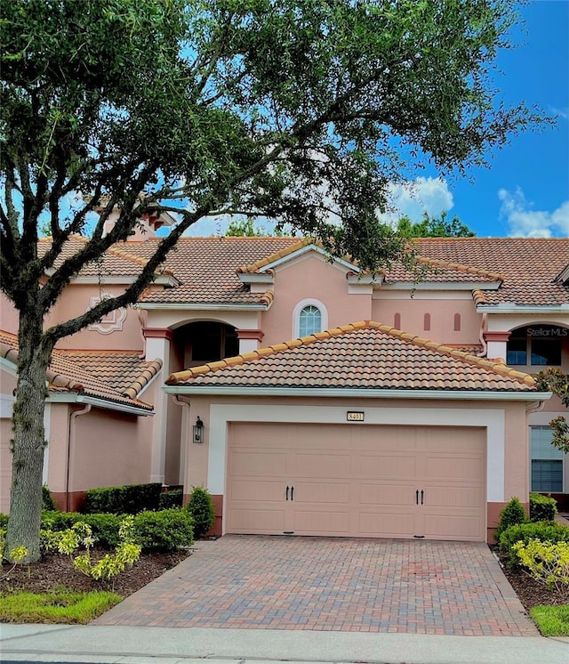8401 Riverdale Ln Unit 8401, Davenport, FL 33896 - mediterranean / spanish house with decorative driveway, a tiled roof, stucco siding, and an attached garage
