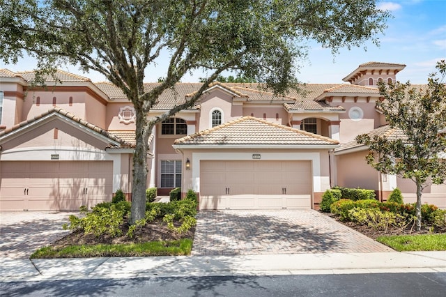 8401 Riverdale Ln Unit 8401, Davenport, FL 33896 - mediterranean / spanish-style home with stucco siding, a garage, a tiled roof, and decorative driveway