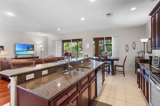 8401 Riverdale Ln Unit 8401, Davenport, FL 33896 - kitchen with appliances with stainless steel finishes, open floor plan, a kitchen island with sink, dark stone counters, and recessed lighting