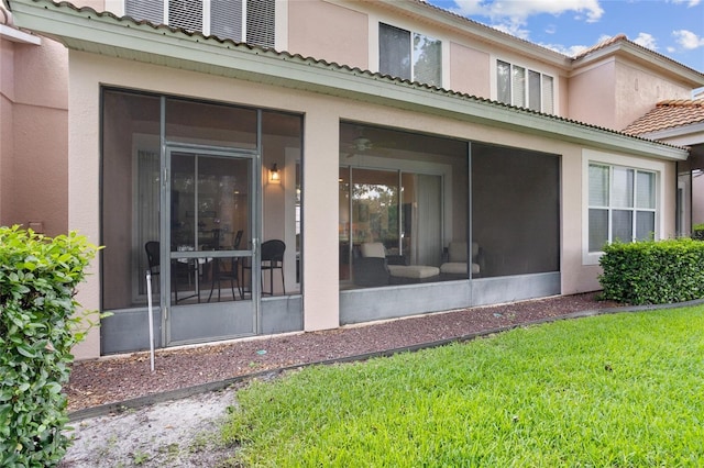 8401 Riverdale Ln Unit 8401, Davenport, FL 33896 - back of property featuring a sunroom, stucco siding, a tile roof, and a lawn