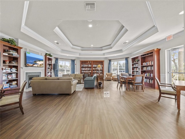 8401 Riverdale Ln Unit 8401, Davenport, FL 33896 - living area featuring a tray ceiling, healthy amount of natural light, wood finished floors, and crown molding