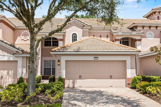 8401 Riverdale Ln Unit 8401, Davenport, FL 33896 - mediterranean / spanish house featuring driveway, a tiled roof, an attached garage, and stucco siding