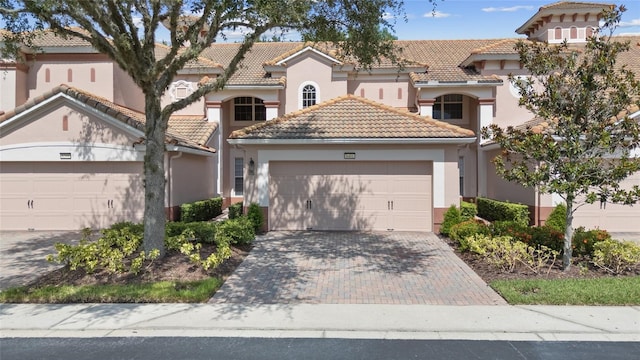 8401 Riverdale Ln Unit 8401, Davenport, FL 33896 - mediterranean / spanish-style home featuring a garage, stucco siding, a tiled roof, and decorative driveway