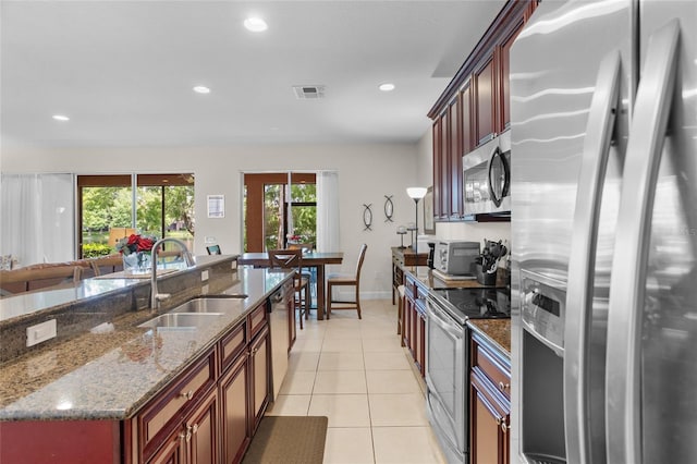 8401 Riverdale Ln Unit 8401, Davenport, FL 33896 - kitchen with appliances with stainless steel finishes, recessed lighting, light tile patterned floors, dark stone counters, and open floor plan