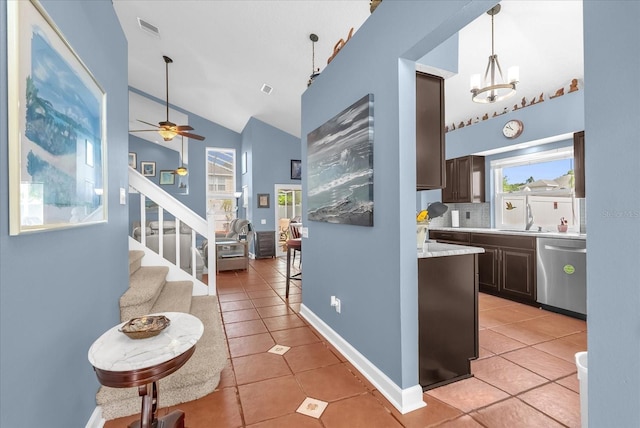 3214 Herons Point Cir, Kissimmee, FL 34741 - kitchen with stainless steel dishwasher, light countertops, dark brown cabinetry, light tile patterned floors, and high vaulted ceiling
