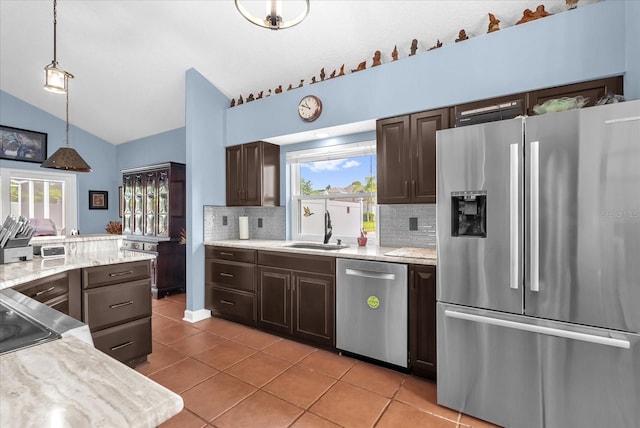 3214 Herons Point Cir, Kissimmee, FL 34741 - kitchen with stainless steel appliances, lofted ceiling, tasteful backsplash, and dark brown cabinets