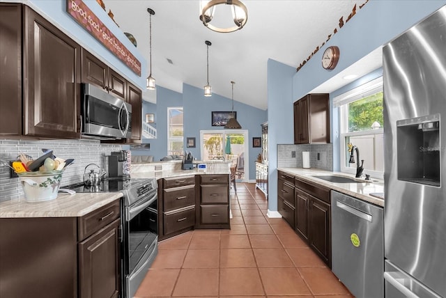 3214 Herons Point Cir, Kissimmee, FL 34741 - kitchen featuring appliances with stainless steel finishes, dark brown cabinetry, and lofted ceiling