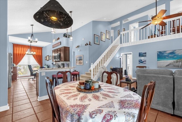 3214 Herons Point Cir, Kissimmee, FL 34741 - dining room featuring ceiling fan, stairway, high vaulted ceiling, tile patterned flooring, and a chandelier