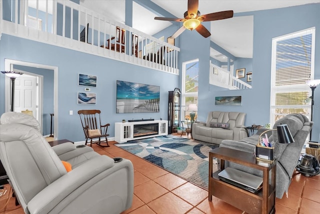 3214 Herons Point Cir, Kissimmee, FL 34741 - living room featuring high vaulted ceiling, tile patterned floors, a ceiling fan, and a glass covered fireplace