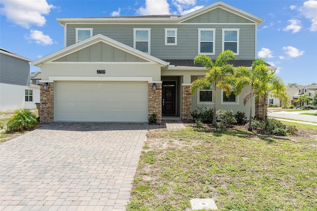 2759 Slash Way, Saint Cloud, FL 34771 - view of front facade featuring board and batten siding, decorative driveway, stone siding, and a garage