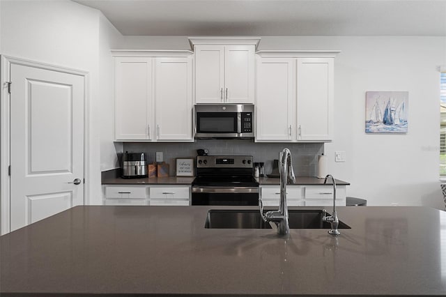 2759 Slash Way, Saint Cloud, FL 34771 - kitchen with stainless steel appliances, dark countertops, tasteful backsplash, and white cabinetry