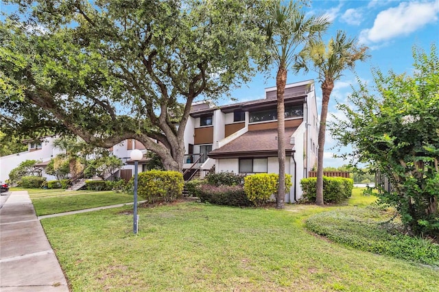 4570 Tower Pine Rd Ge, Unit Ge, Orlando, FL 32839 - rear view of property featuring stucco siding and a lawn