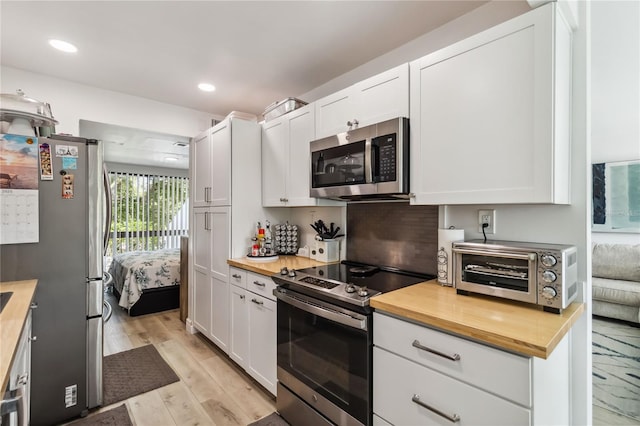 4570 Tower Pine Rd Ge, Unit Ge, Orlando, FL 32839 - kitchen with appliances with stainless steel finishes, wood counters, white cabinetry, light wood-style floors, and recessed lighting